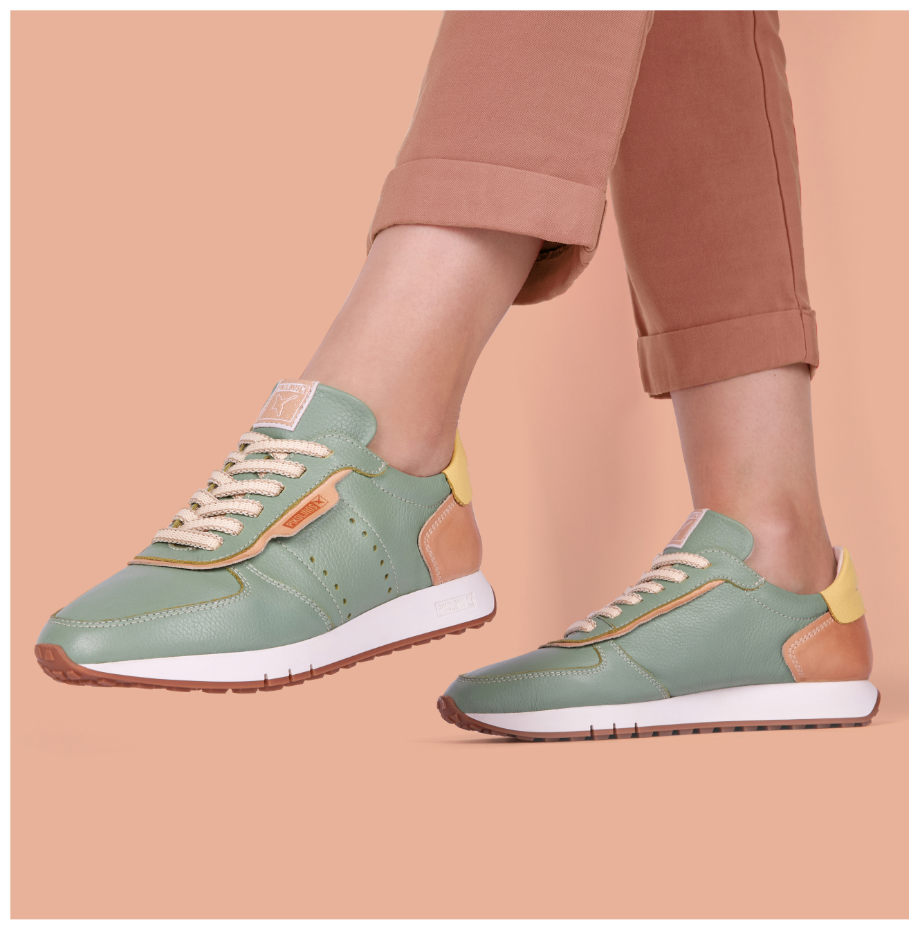 Women's green sneakers on an orange background
